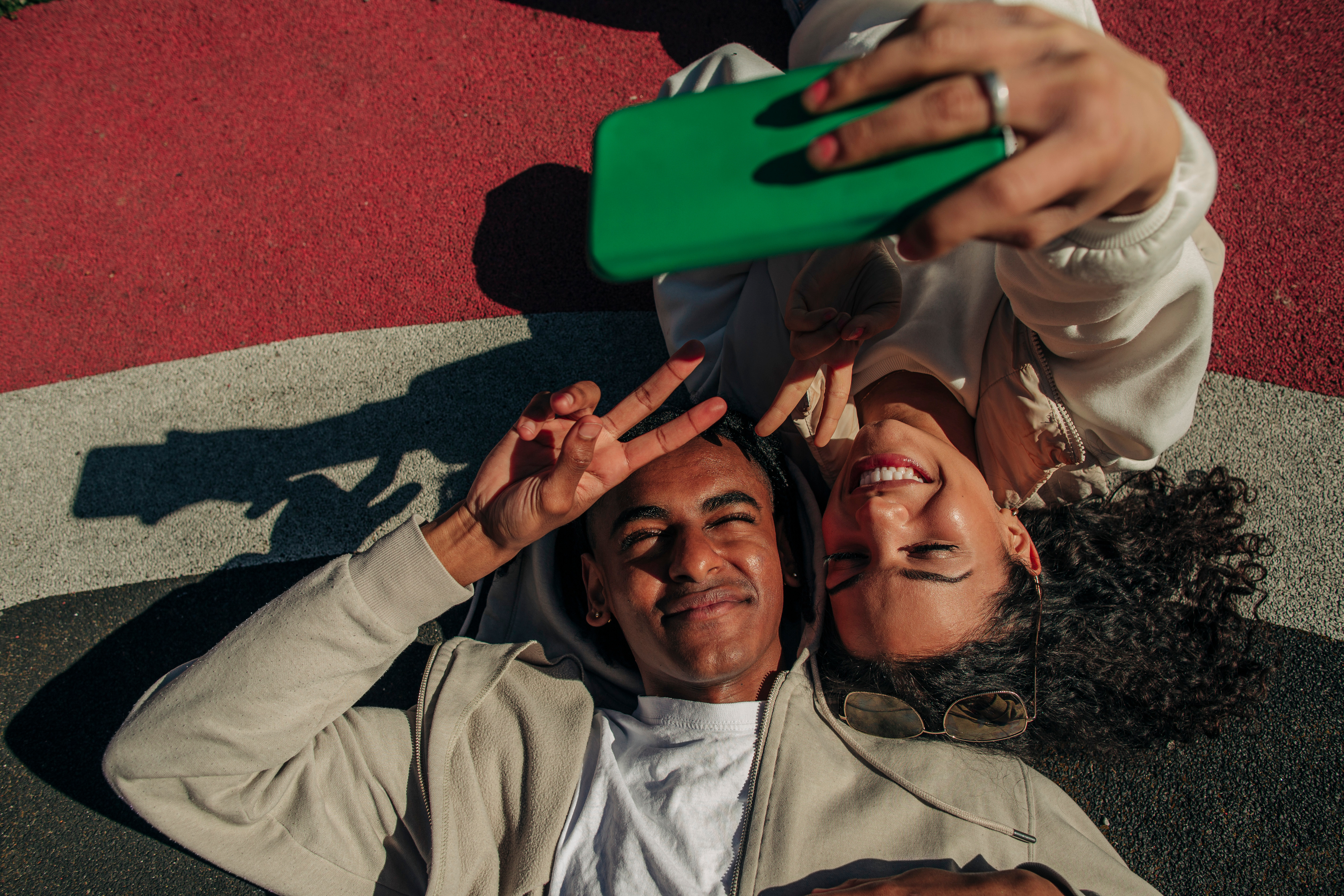 Kompisar gör peace tecknet och tar selfie med smartphone